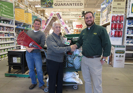 The winner of the Russell Lake Takes Root raffle prize receives his winnings at Kent Building Supplies Russell Lake